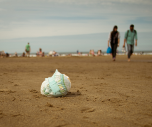 A dispobale nappy discarded on a beach