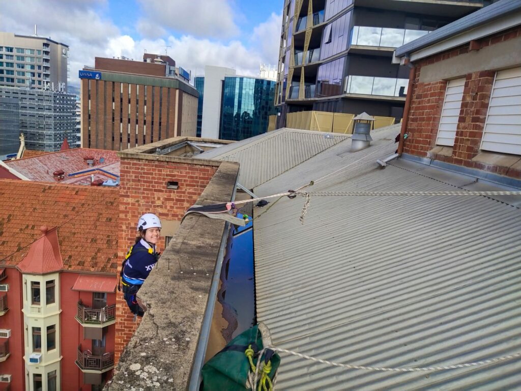 Hannah abseiling from a building in Melbourne to conduct a facade inspection. 