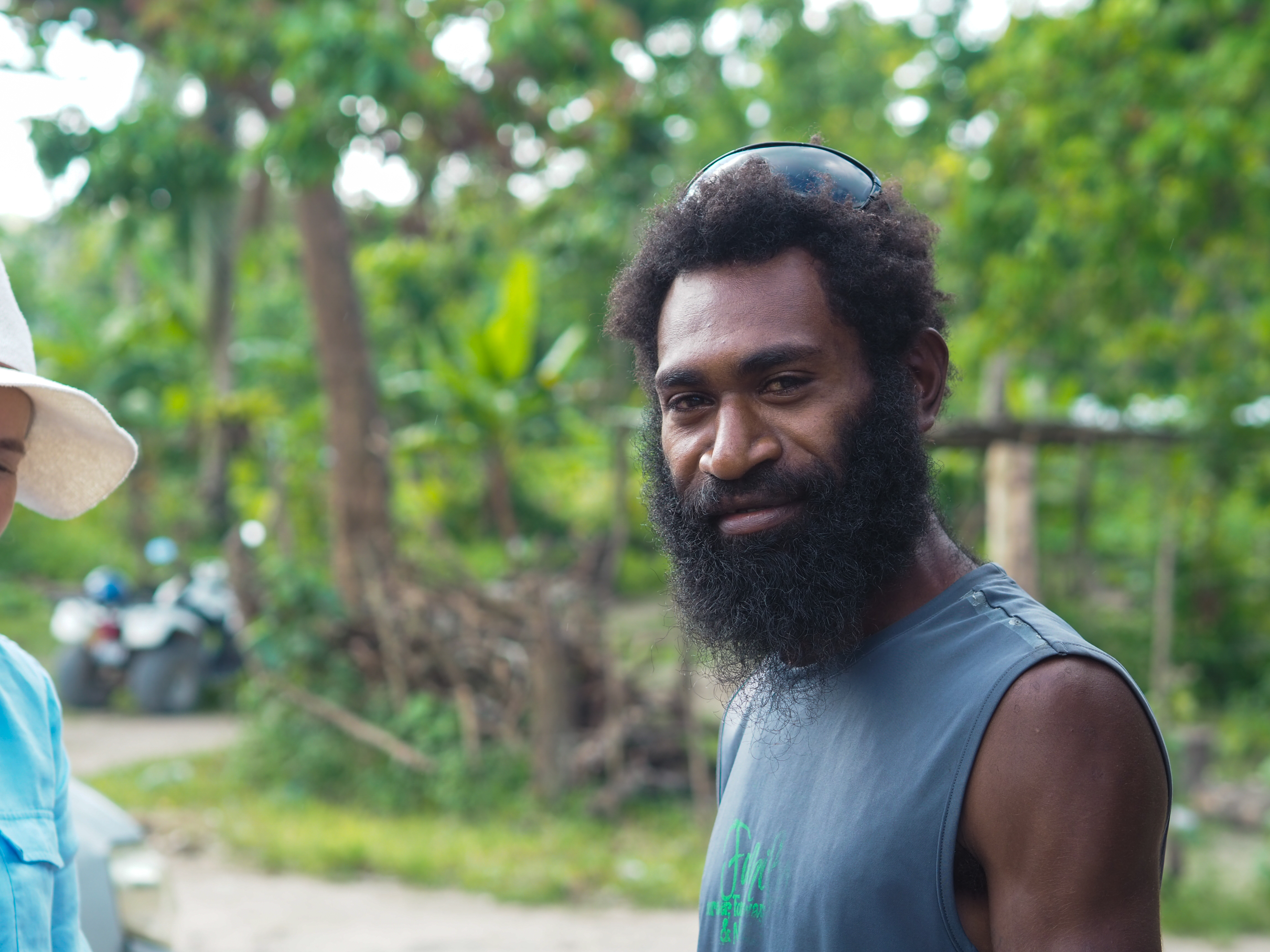 David Kalsal smiles in Erakor Bridge village, Vanuatu, surrounded by tropical greenery
