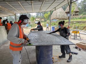 Timorese man and two women resurfacing plastic panels for the project