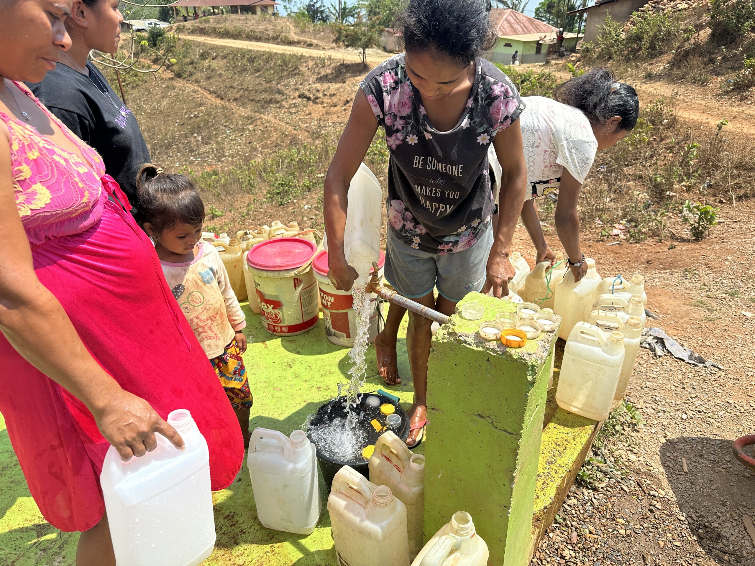 Community members collecting clean water at a rehabilitated water point in Timor-Leste